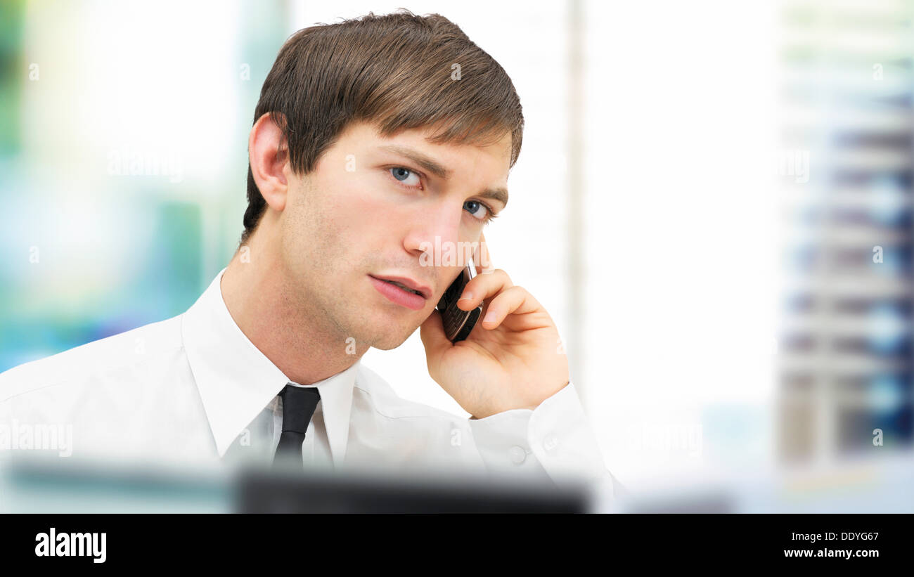 Businessman with a serious face speaking on his mobile phone, portrait, focused Stock Photo