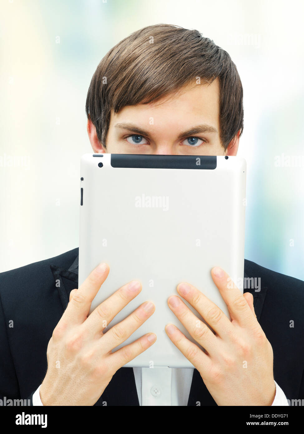 Businessman holding an iPad in front of his face Stock Photo