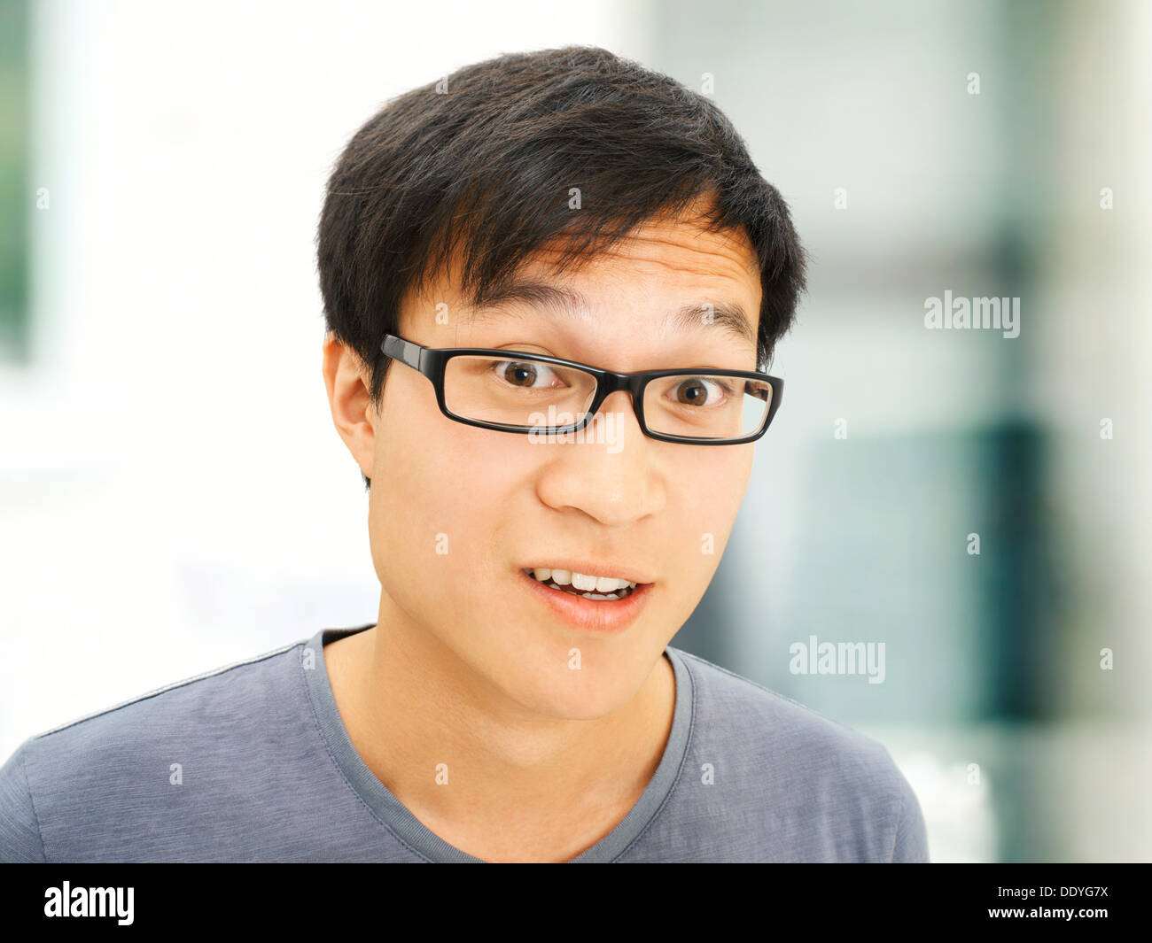 Young man, Asian, student with glasses, smiling, surprised Stock Photo -  Alamy