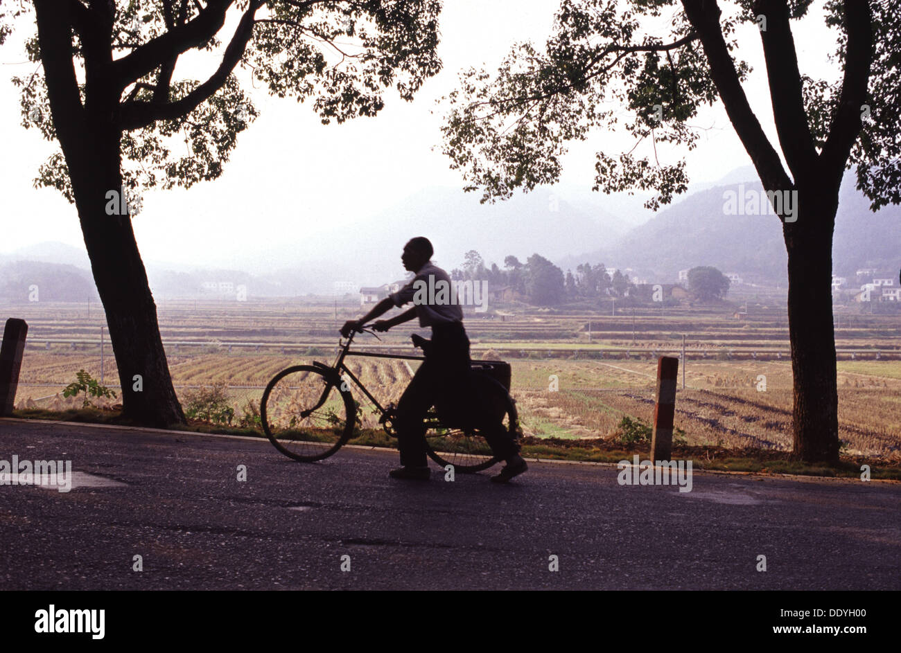 Chinese man walks with his bicycle in Shaoshan county level city in Xiangtan, Hunan Province, noted as the birthplace of Mao Zedong China Stock Photo