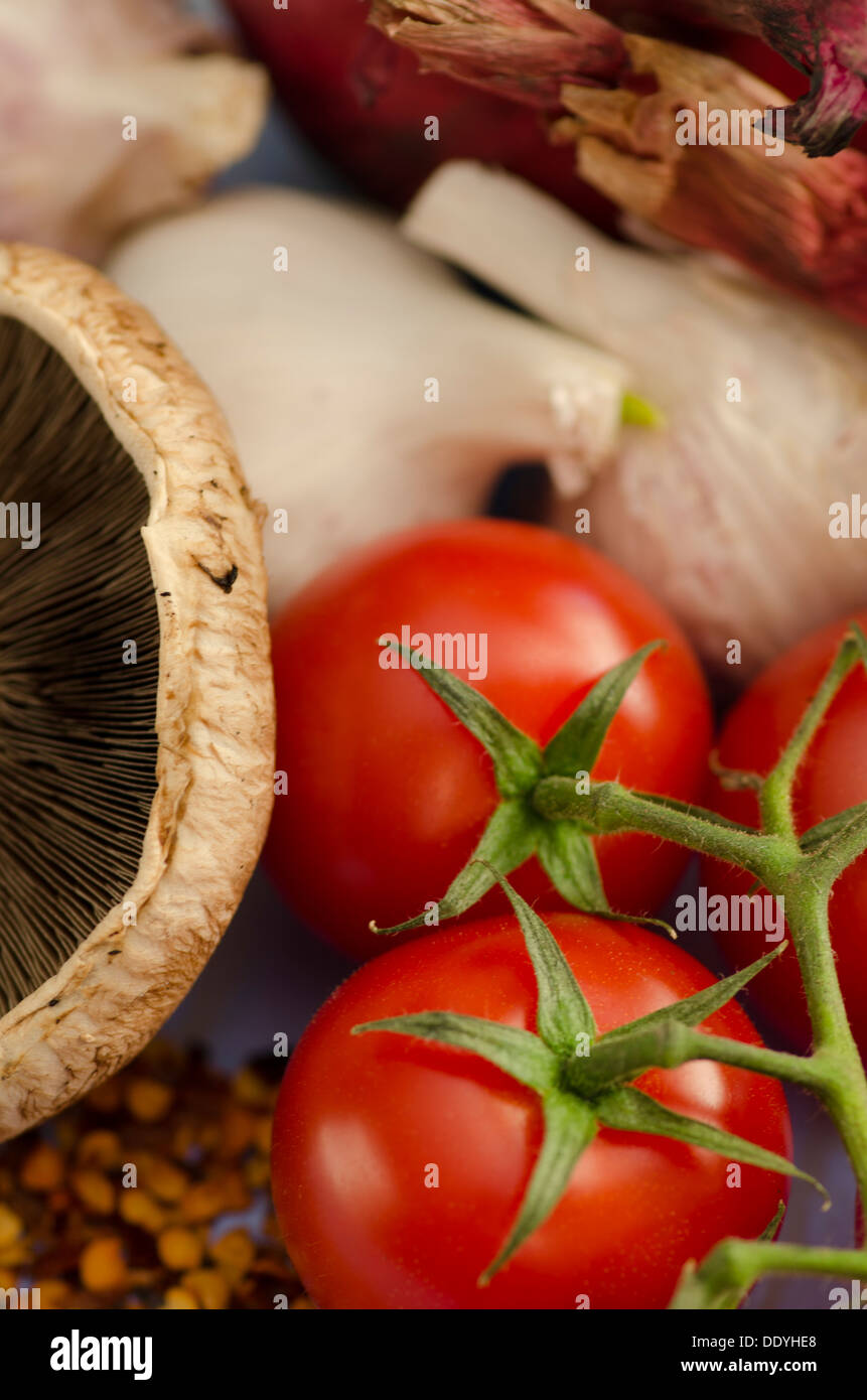 Closeup of fresh cherry tomatoes and a mushroom ready for use as ingredients in cooking a healthy vegetarian meal Stock Photo