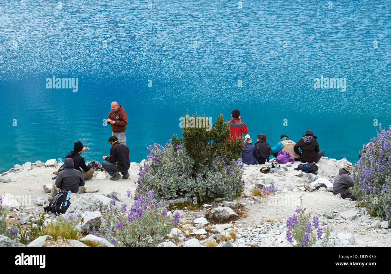 Tourists resting at Laguna 69 trek in the Huascarán National Park, Peruvian Andes. Stock Photo