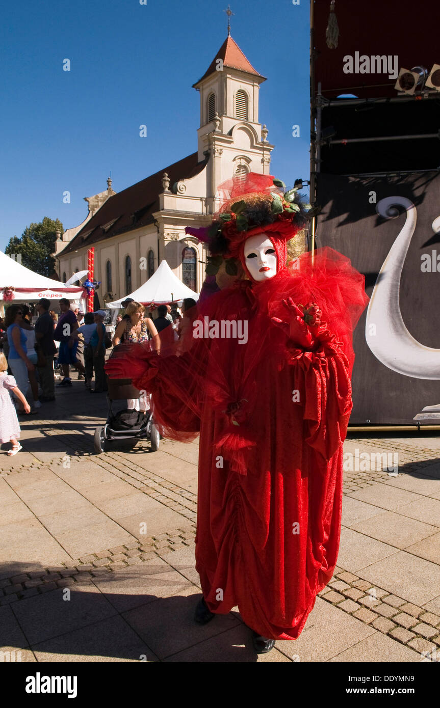 Performer wearing a white mask and a red costume, Venezianische Messe, Venetian festival, Ludwigsburg, Baden-Wuerttemberg Stock Photo
