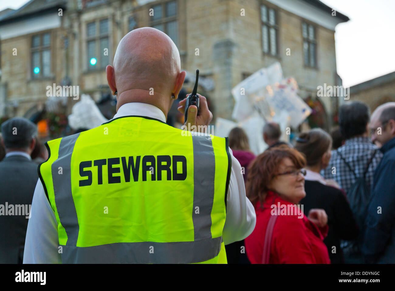 Bald male man steward talking on walkie talkie at event Stock Photo