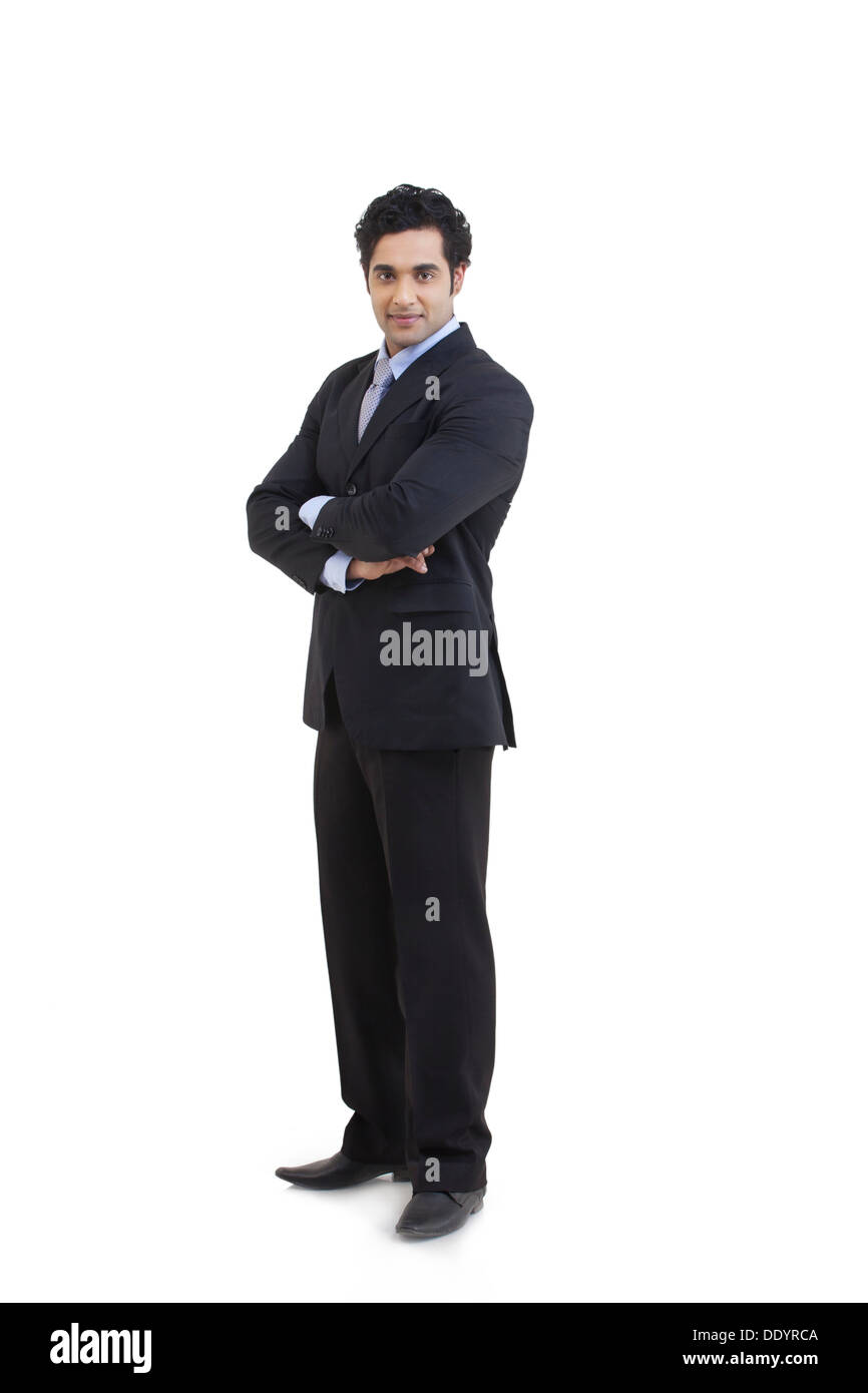 Full length portrait of young businessman with arms crossed standing ...