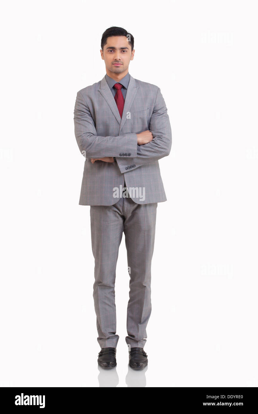 Full length portrait of young businessman with arms crossed standing ...