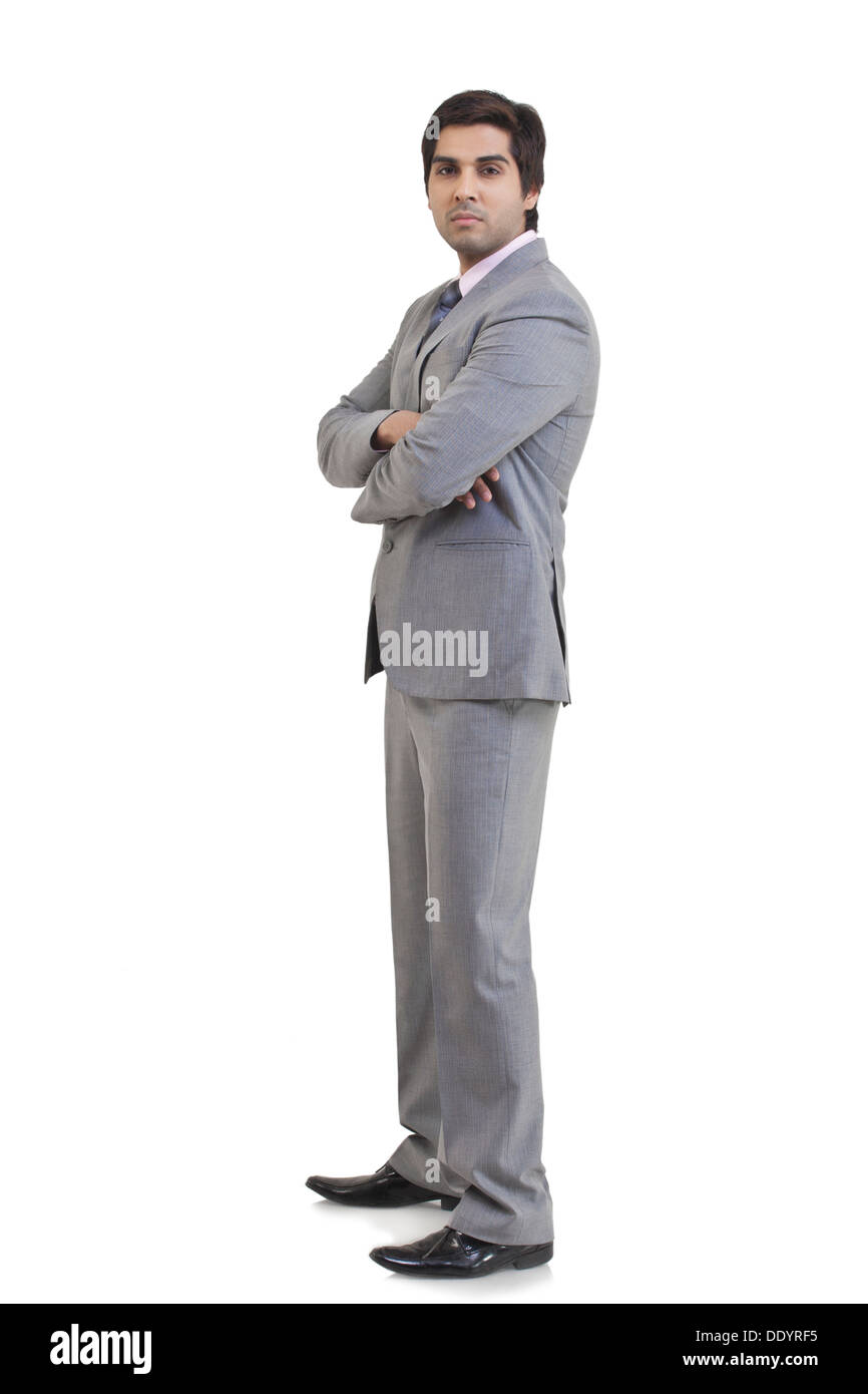Full length portrait of young businessman with arms crossed standing ...