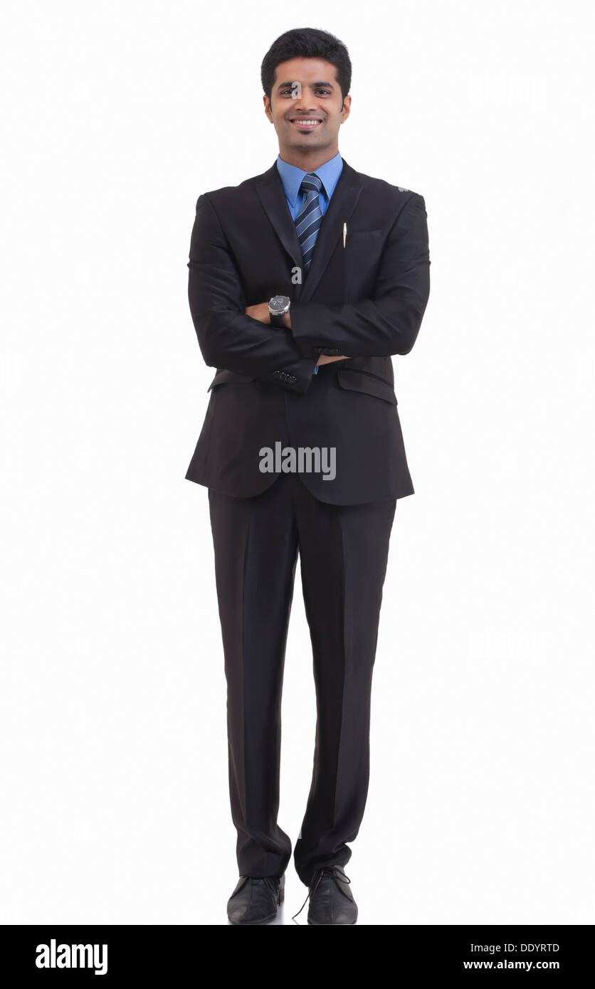 Full length portrait of happy young businessman with arms crossed ...