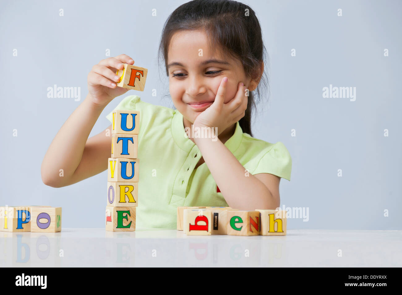 Little girl stacking blocks isolated over blue background Stock Photo