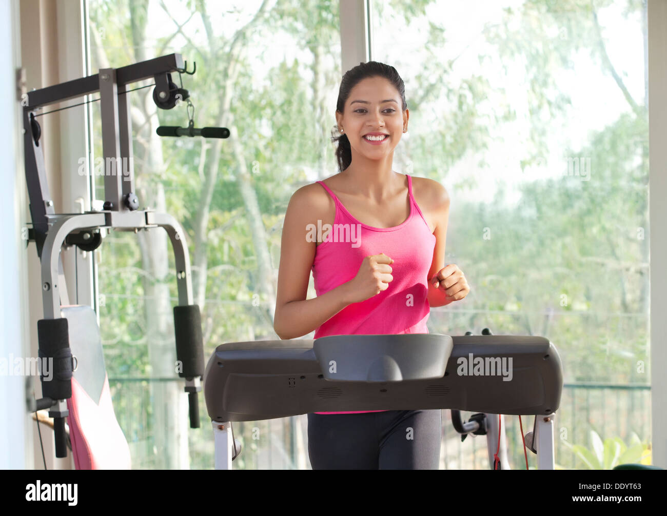 Young woman working out on treadmill Stock Photo. 