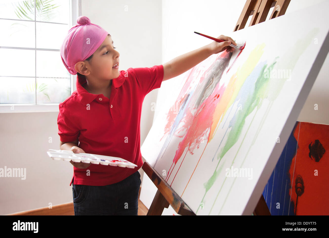 Cute little boy painting on artist's canvas Stock Photo - Alamy