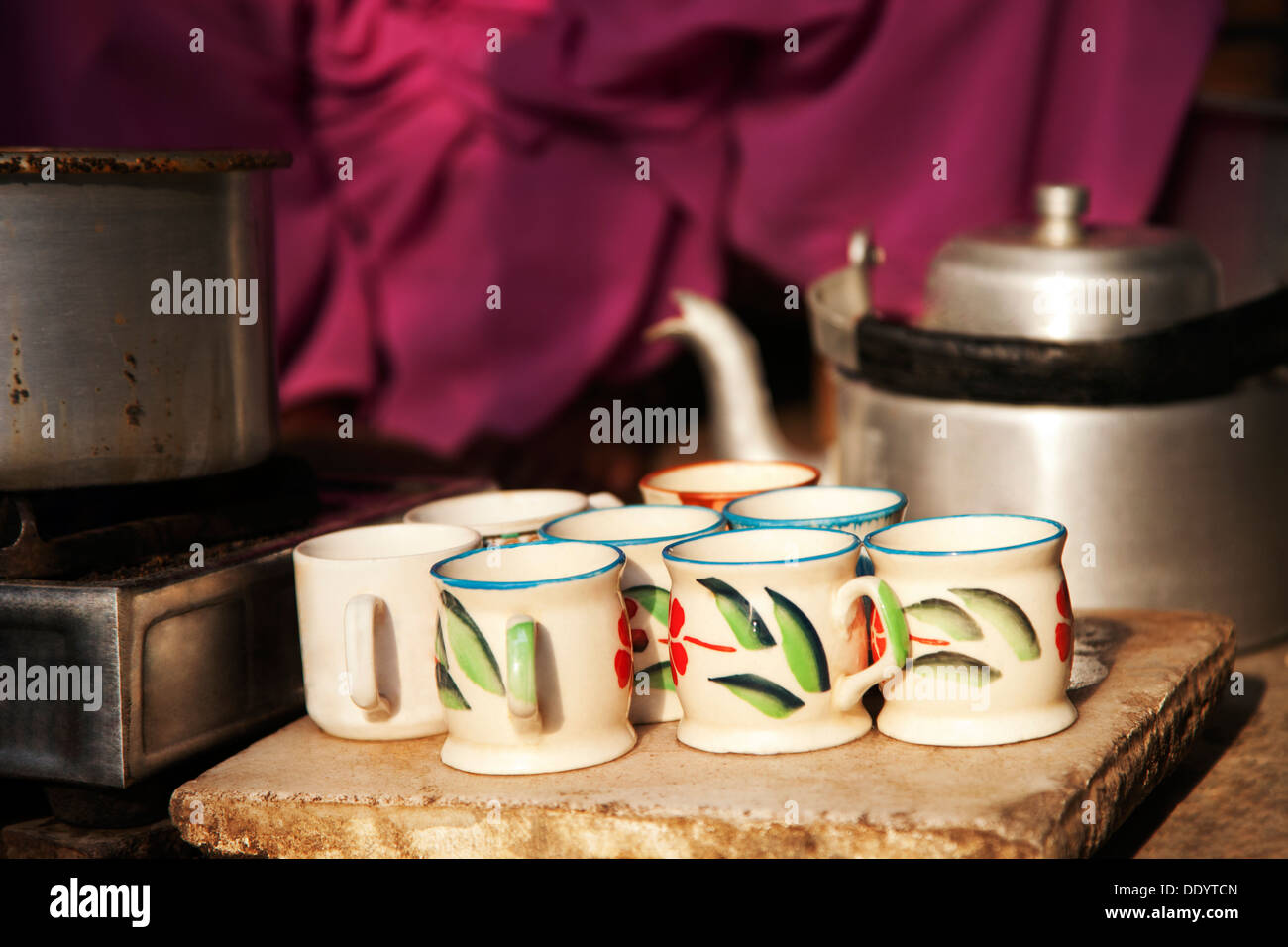 https://c8.alamy.com/comp/DDYTCN/tea-cups-pan-on-stove-and-kettle-at-street-market-stall-DDYTCN.jpg