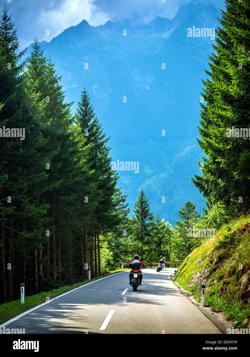 Bikers on the road in Alps, European tour, active lifestyle, driving motorcycle, enjoying freedom, summer holidays Stock Photo