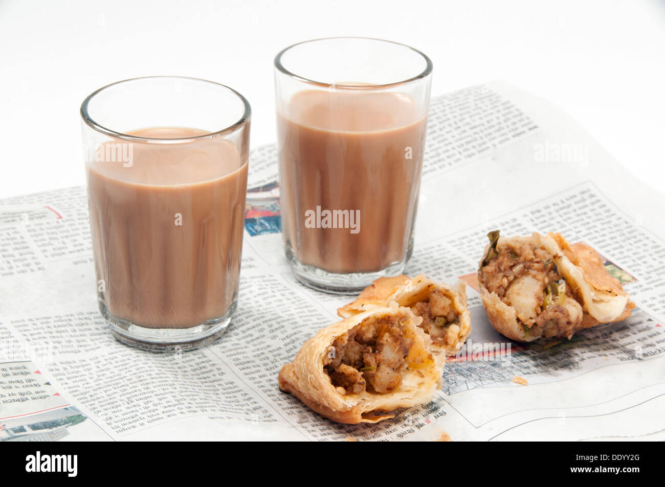 Indian chai with samosas on newspaper isolated over white background Stock Photo