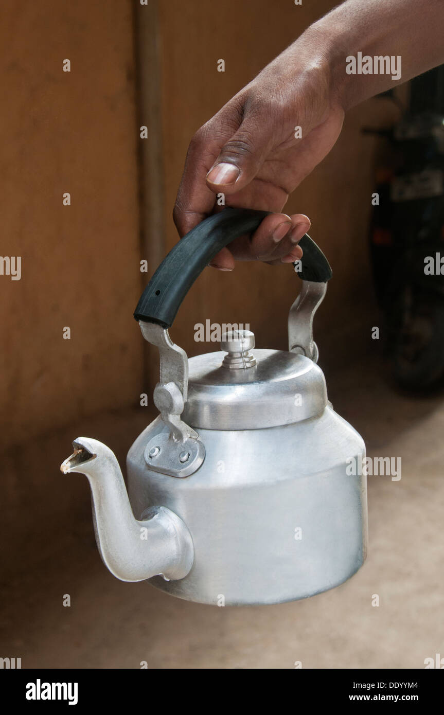 https://c8.alamy.com/comp/DDYYM4/close-up-of-males-hand-holding-an-old-fashioned-tea-kettle-DDYYM4.jpg