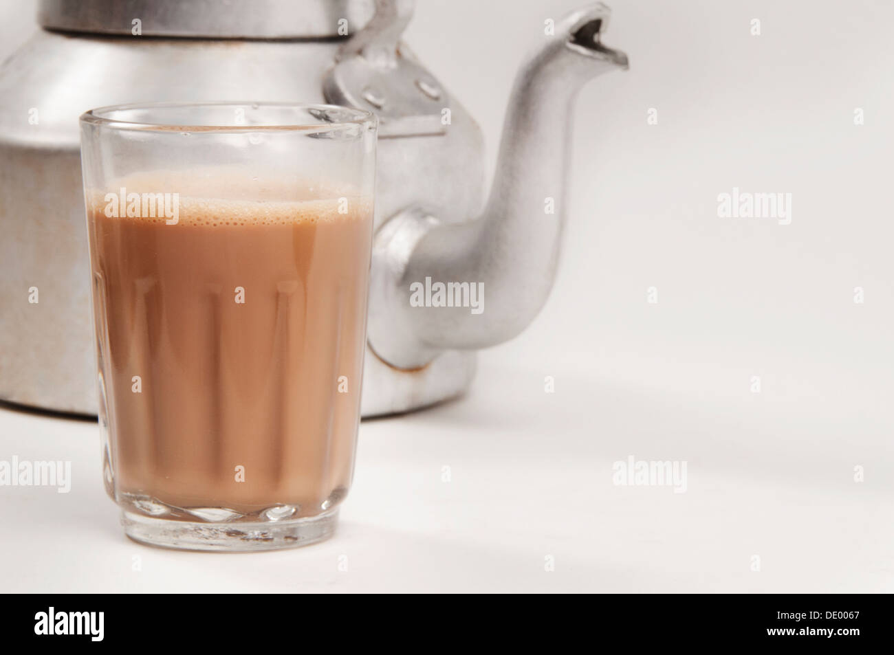 https://c8.alamy.com/comp/DE0067/glass-of-chai-with-an-old-fashioned-kettle-isolated-over-white-background-DE0067.jpg