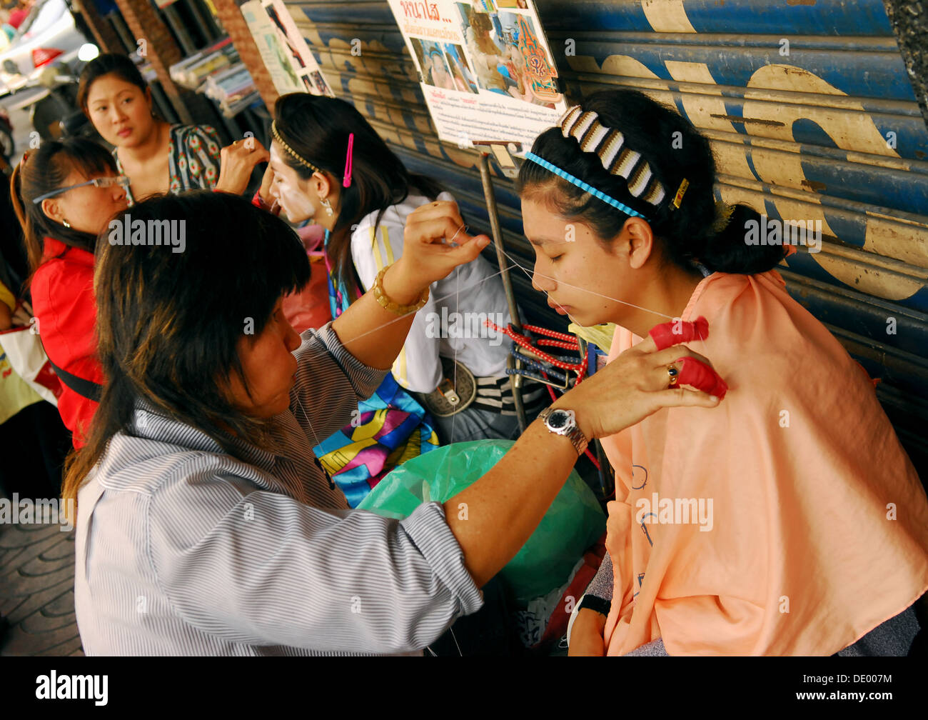 Facial Threading on the sidewalk in Bangkok Chinatown, Thailand Stock