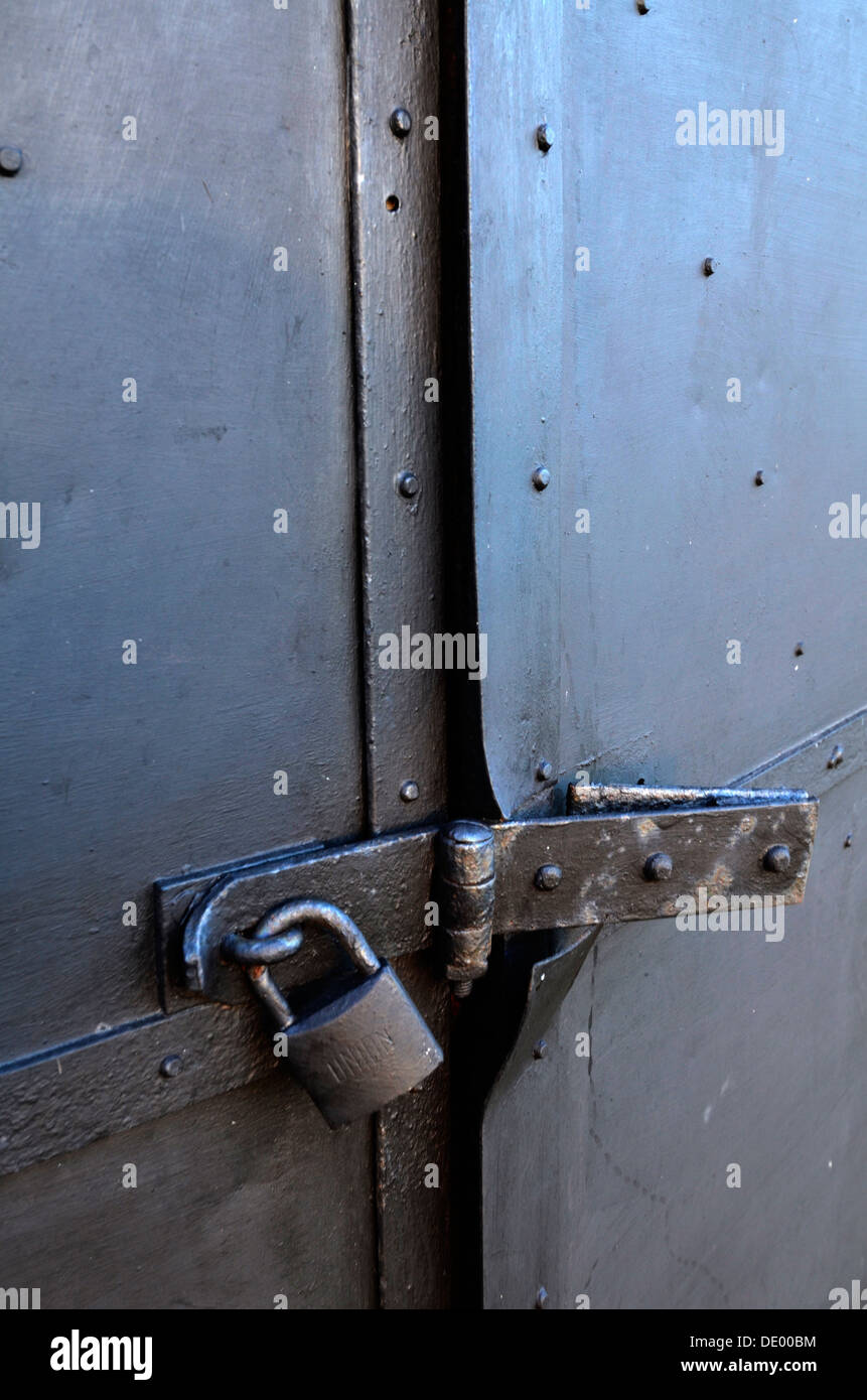 Security... a old metal door secured with padlock, hasp and staple Stock Photo