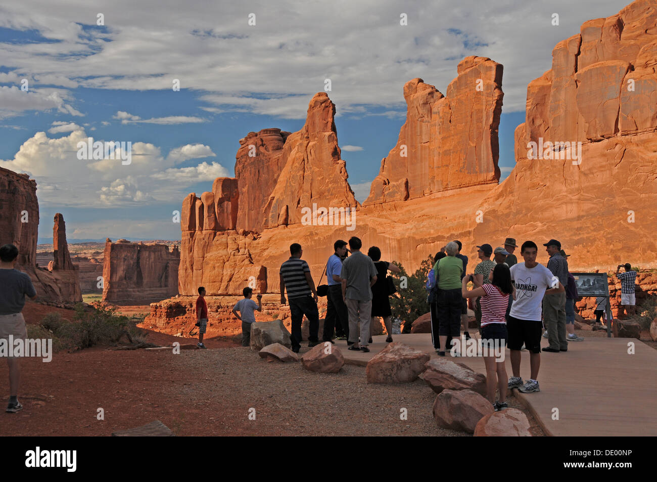 Visitors enjoying scenic view of Courthouse Towers in Arches National Park in Utah at sunrise Stock Photo