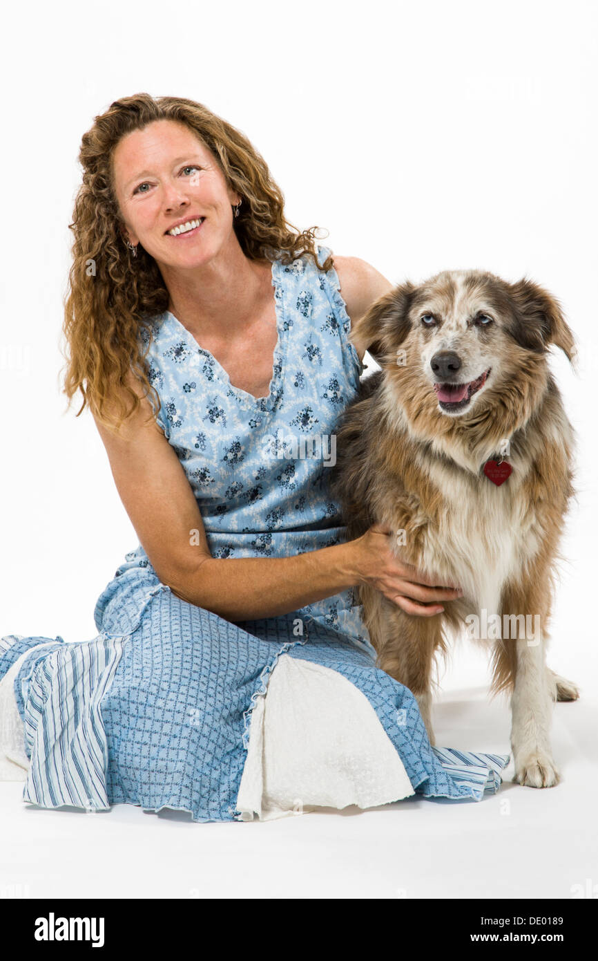 Studio photograph of attractive woman in summer dress with her pet dog, Miss Kitty, an Australian Shepherd mix Stock Photo