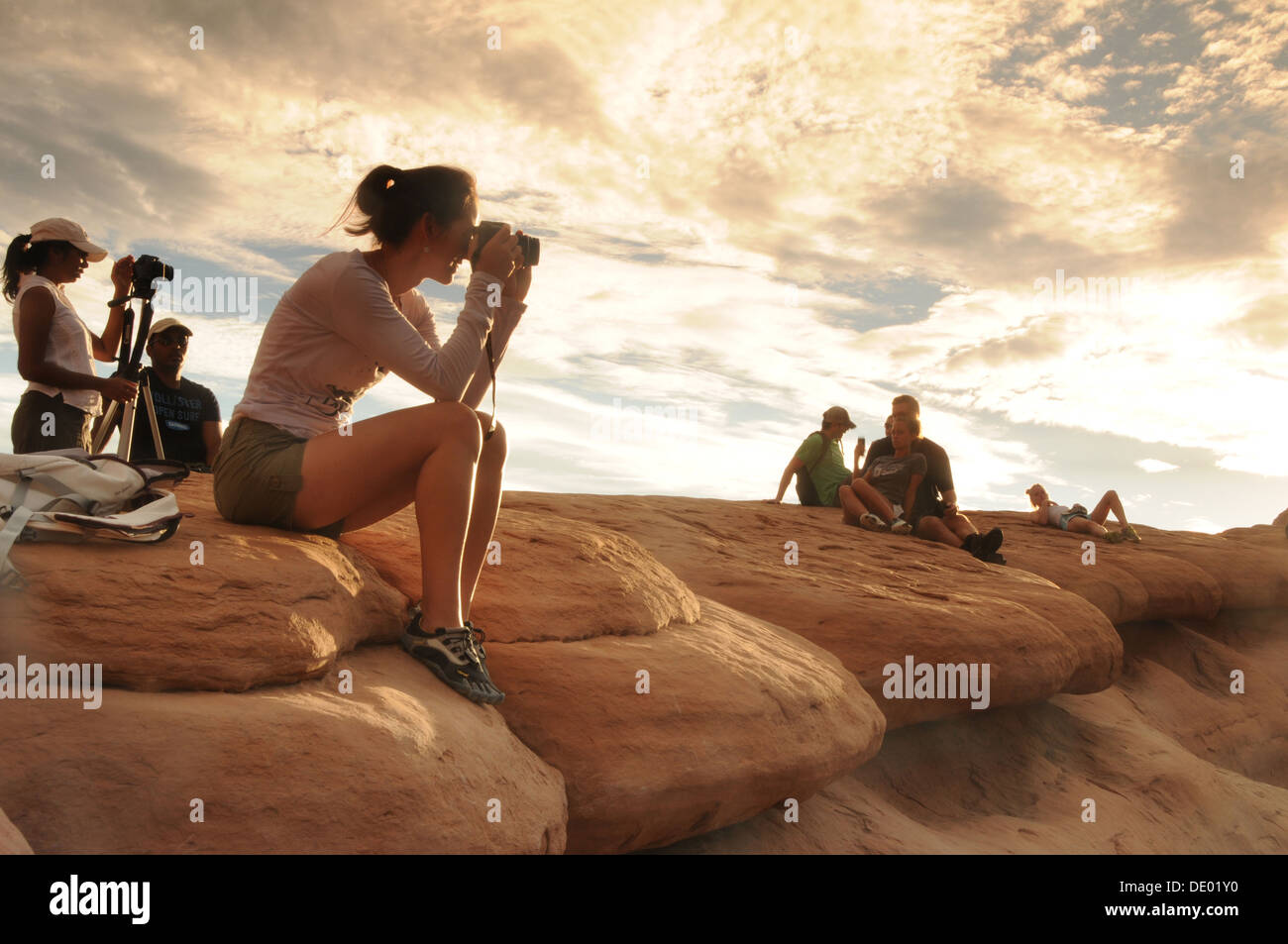 Visitors at Delicate Arch in Arches National Park in Utah taking photos at sunrise Stock Photo