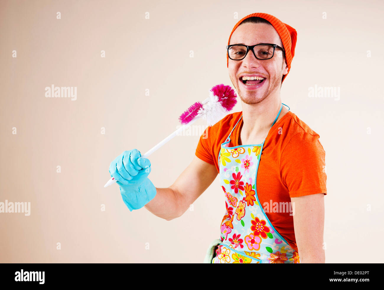 Young man holding a toilet brush in his hand while doing the housework Stock Photo