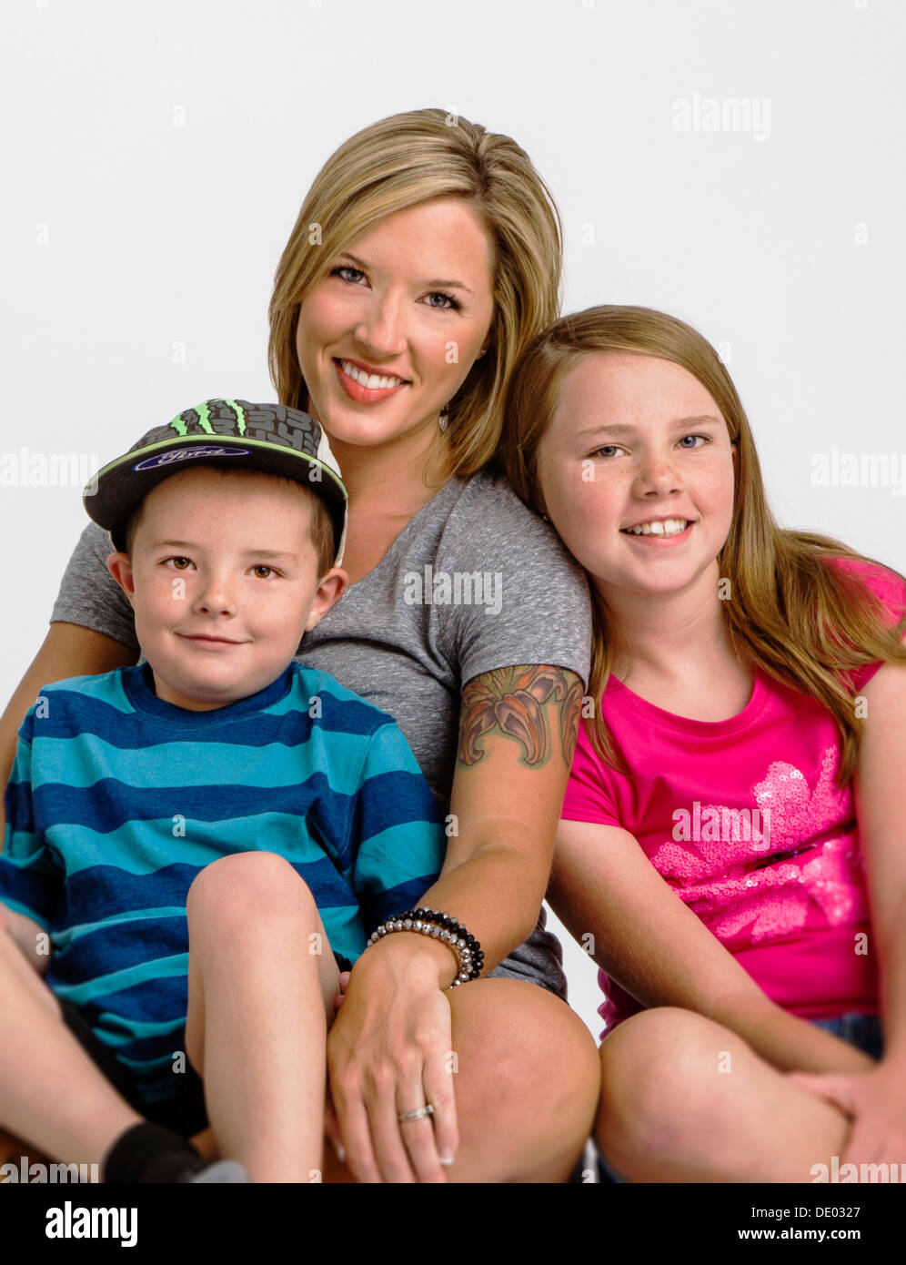 Studio portrait of young mother with five year old son and ten year old daughter Stock Photo