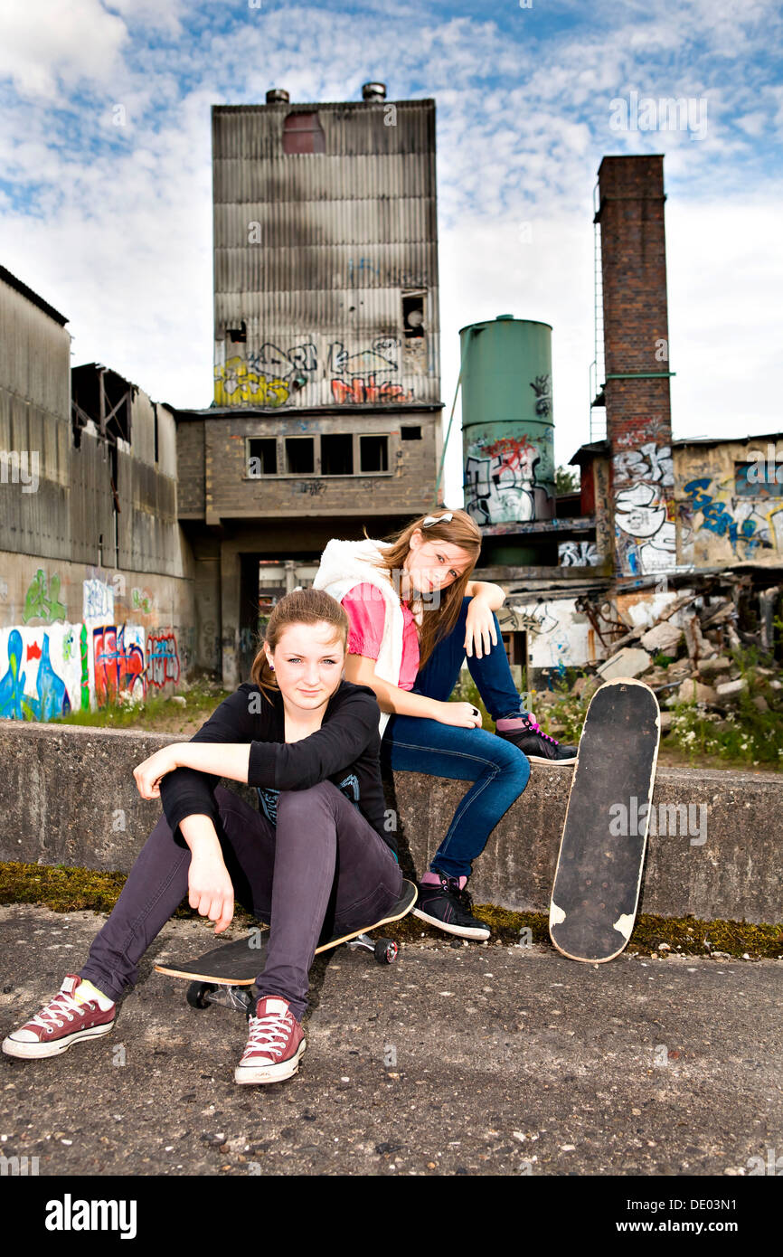 Two young teenage girls with skateboards in an urban area Stock Photo