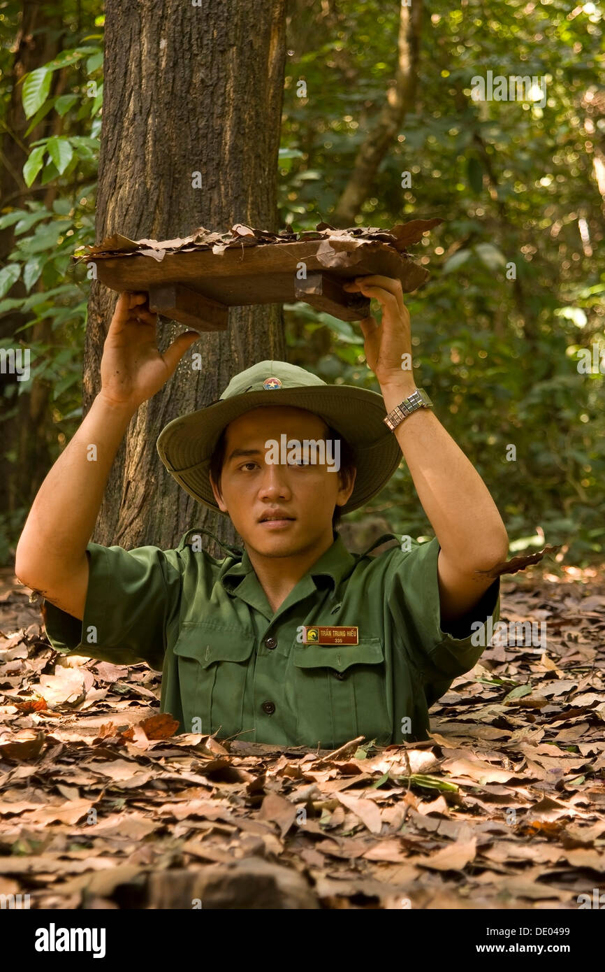 Vietnam soldier showing the entrance to the tunnel system of the Viet Cong in Chu Chi, Vietnam, Asia Stock Photo