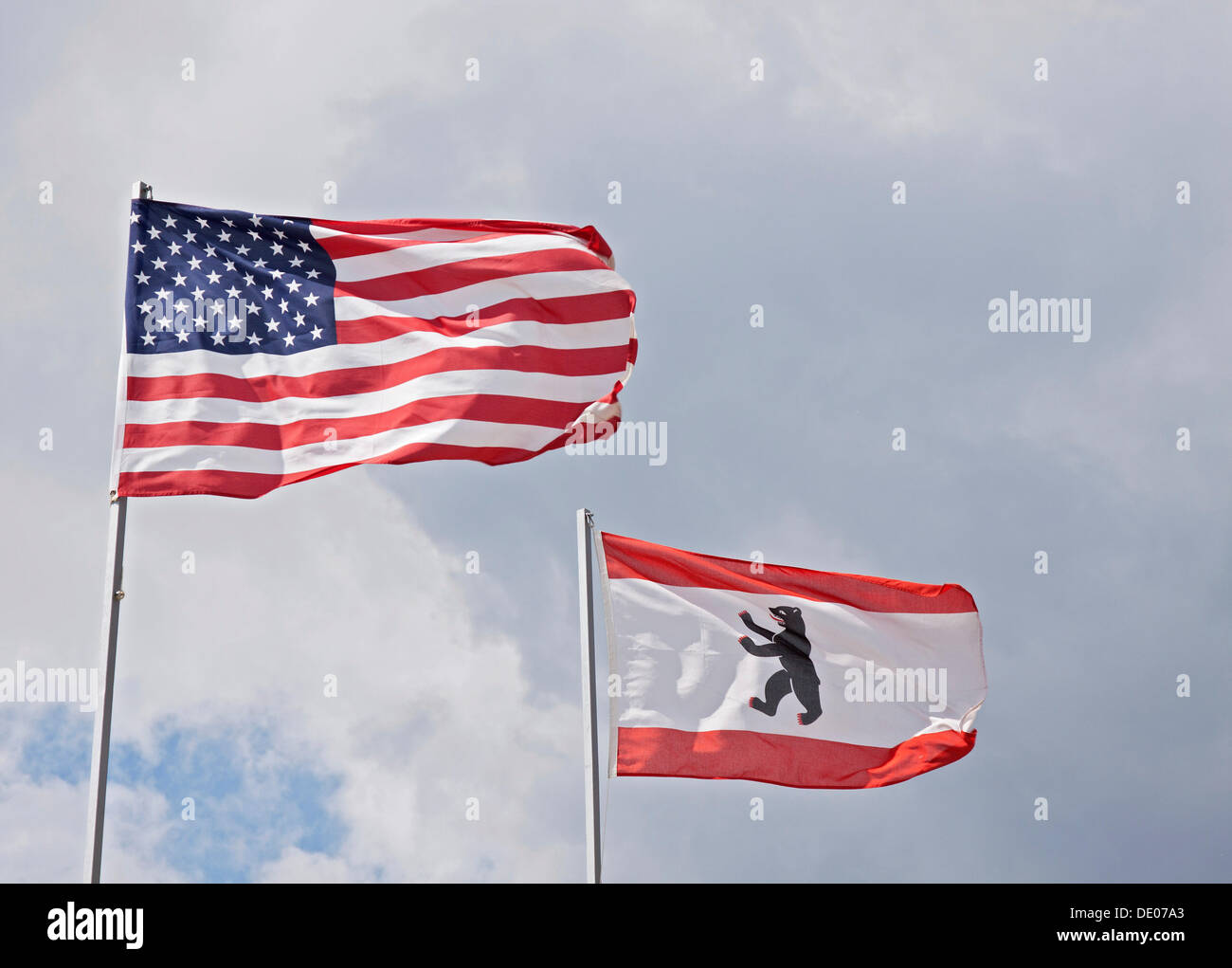 Flags of the USA and Berlin blowing in the wind, stormy Stock Photo