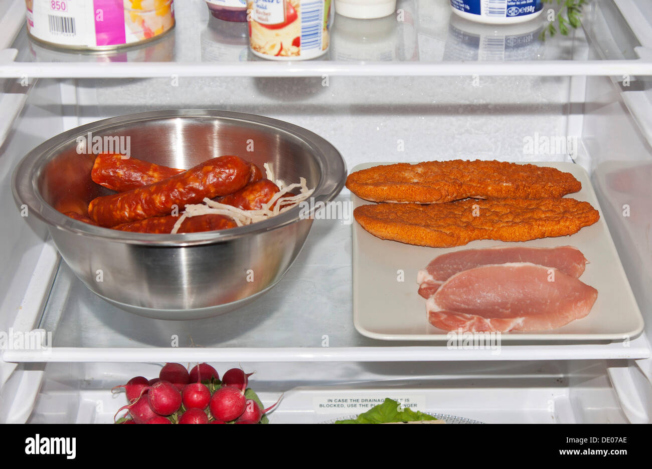 Wrong food storage in a fridge, uncovered meat Stock Photo