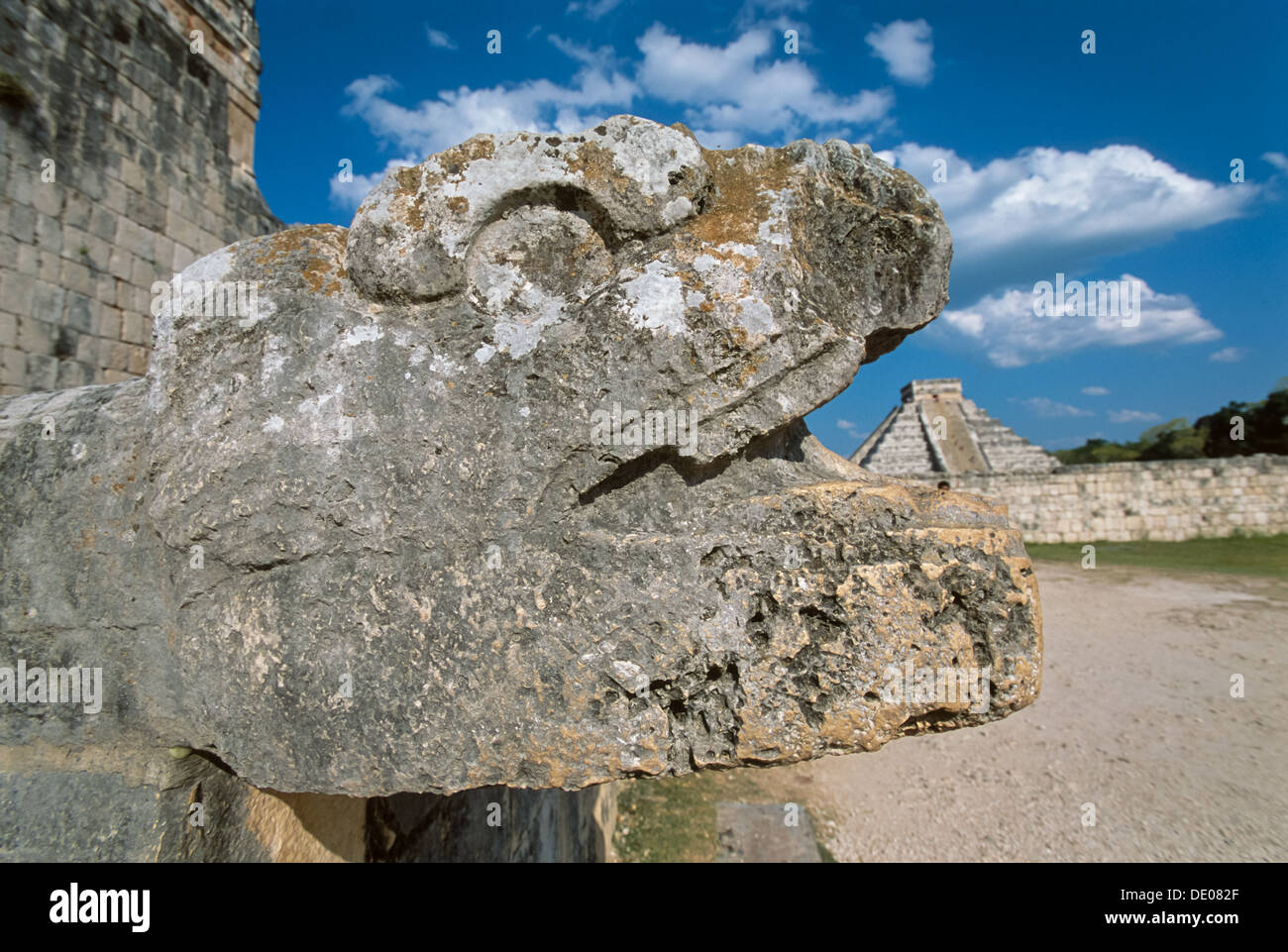 Snake head stone carving on the Temple of Jaguars appearing to swallow Kukulkan's Pyramid (El Castillo), Chichen Itza, Yucatan, Mexico Stock Photo