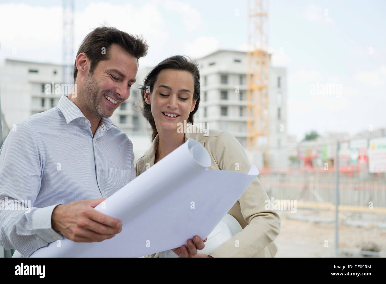 Architects reviewing blueprint in construction site Stock Photo