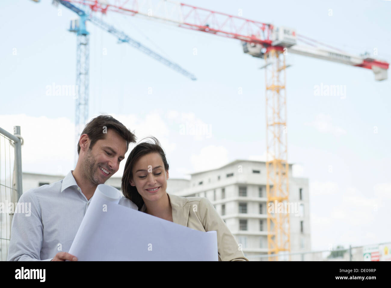 Architects reviewing blueprint in construction site Stock Photo