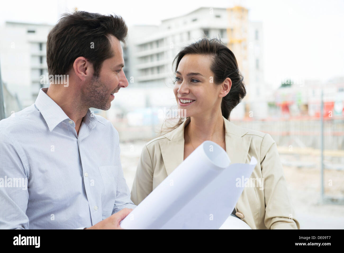 Architects discussing blueprint in construction site Stock Photo