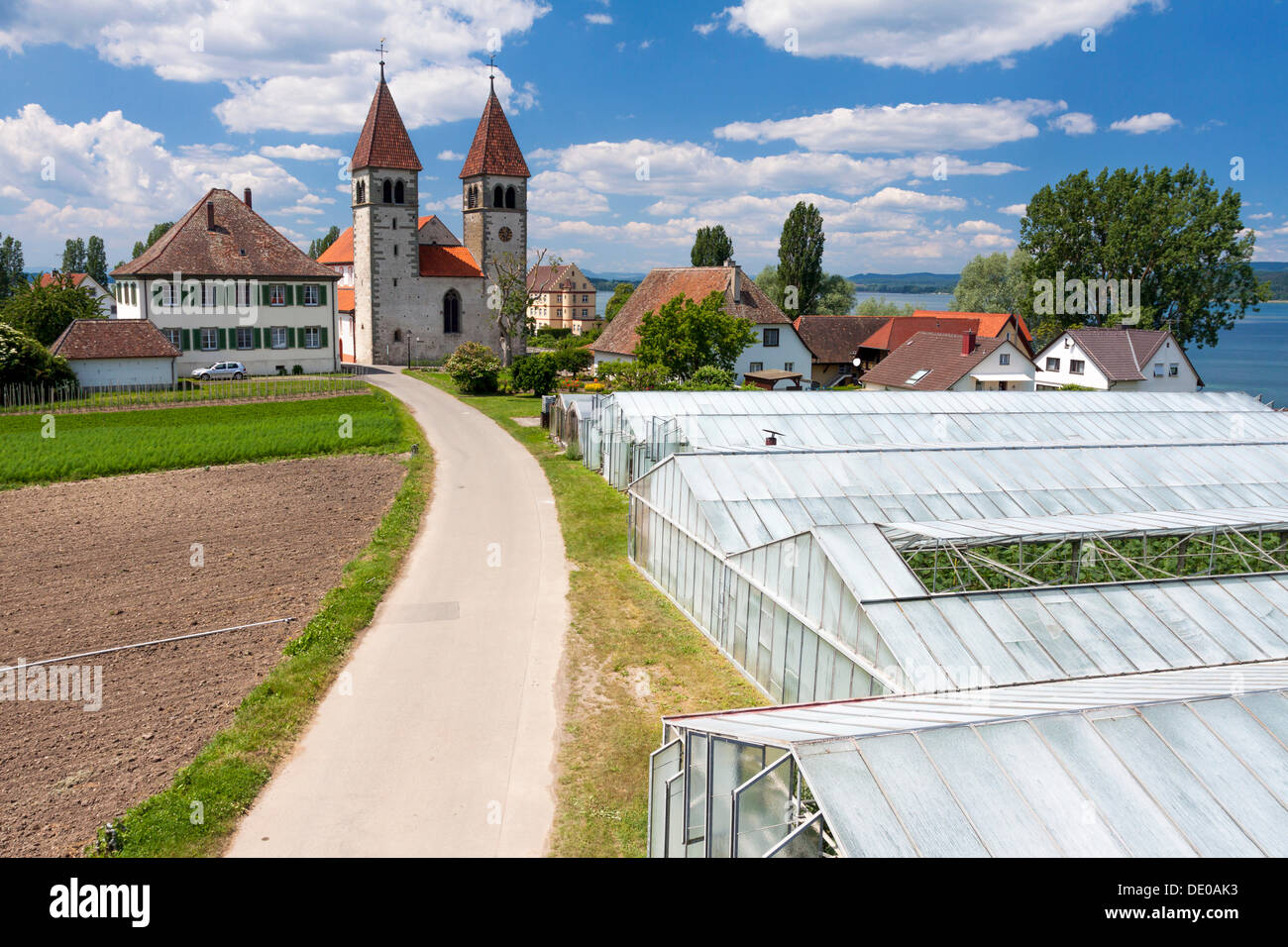 Church of St. Peter and Paul with greenhouses, in Niederzell on Reichenau Island, Lake Constance, Baden-Wuerttemberg Stock Photo