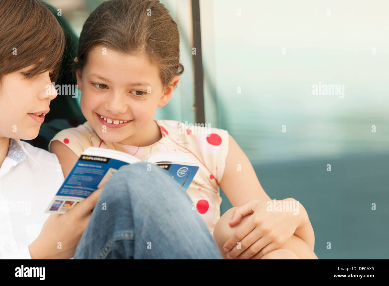 Brother and sister reading guidebook together Stock Photo