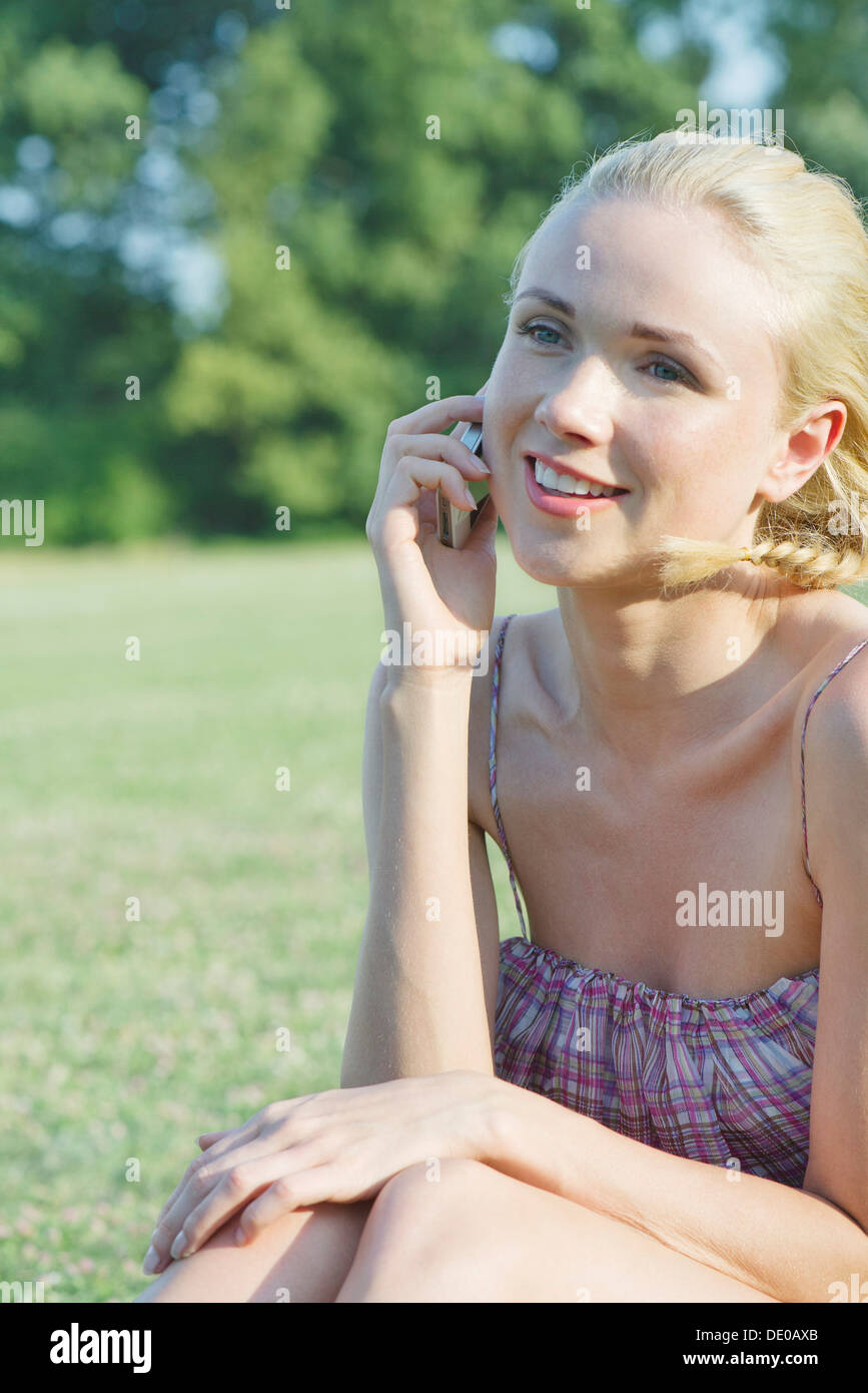 Young woman talking on cell phone outdoors Stock Photo