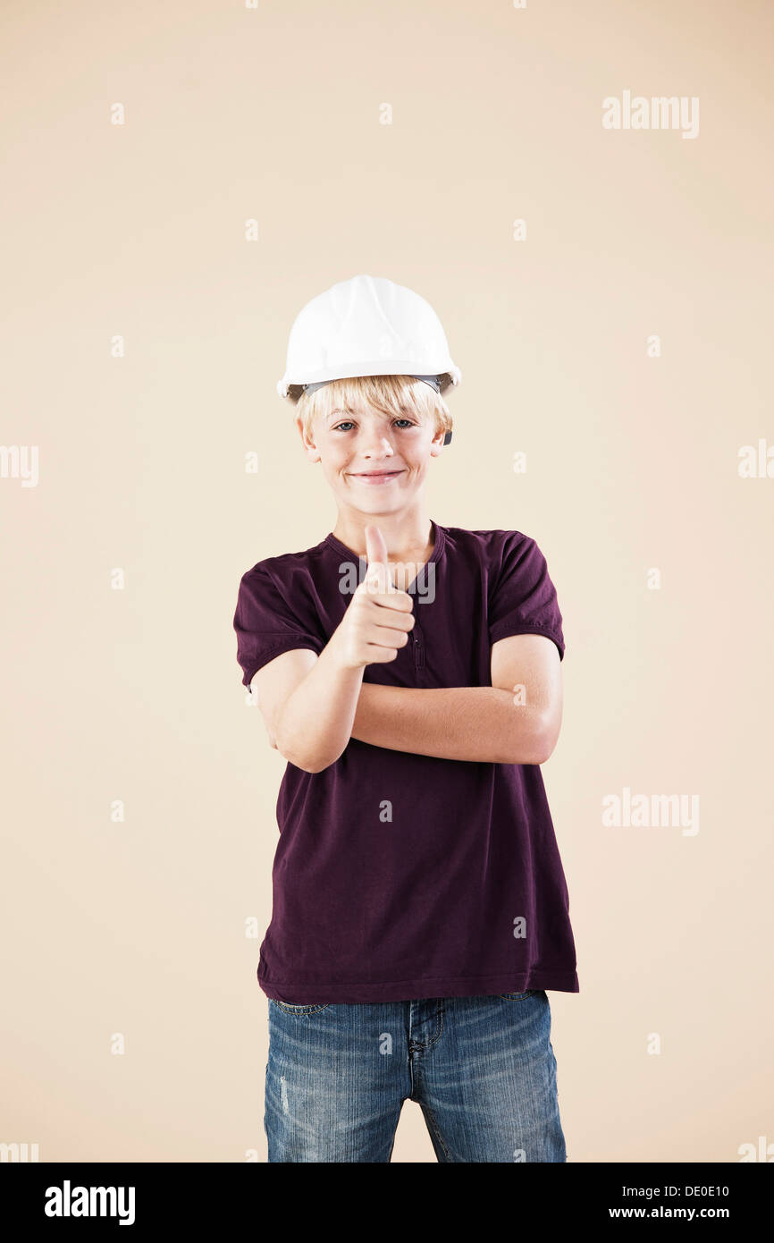 Boy with a hard hat, making thumbs up gesture Stock Photo Alamy