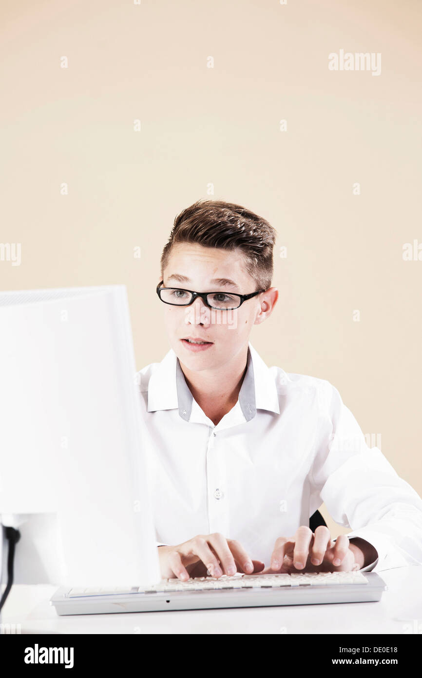 Boy working on a computer at his desk Stock Photo - Alamy