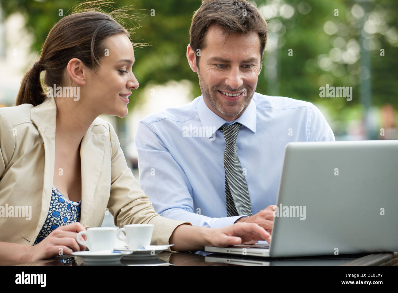 Business associates working together using laptop computer outdoors Stock Photo