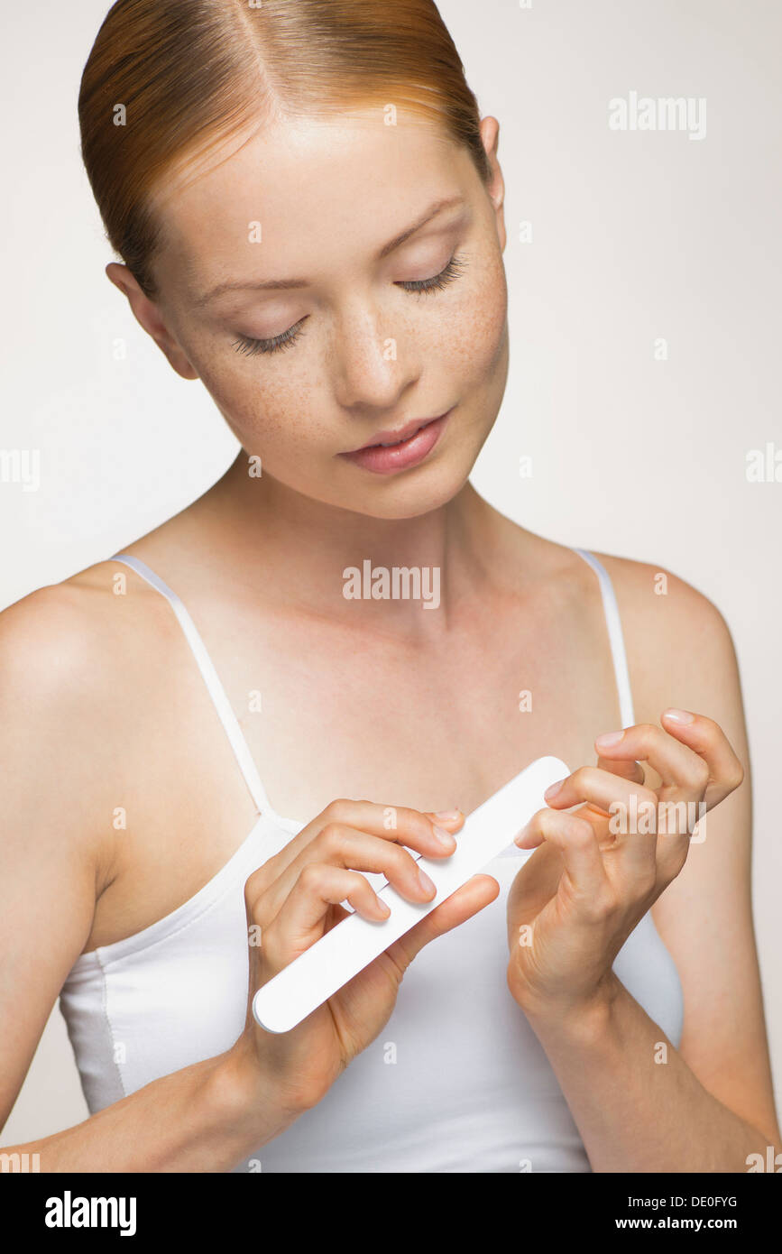 Young woman filing fingernails Stock Photo