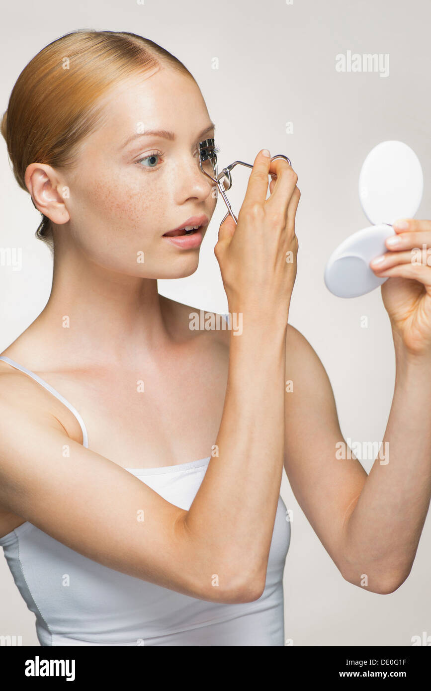 Young woman using eyelash curler Stock Photo