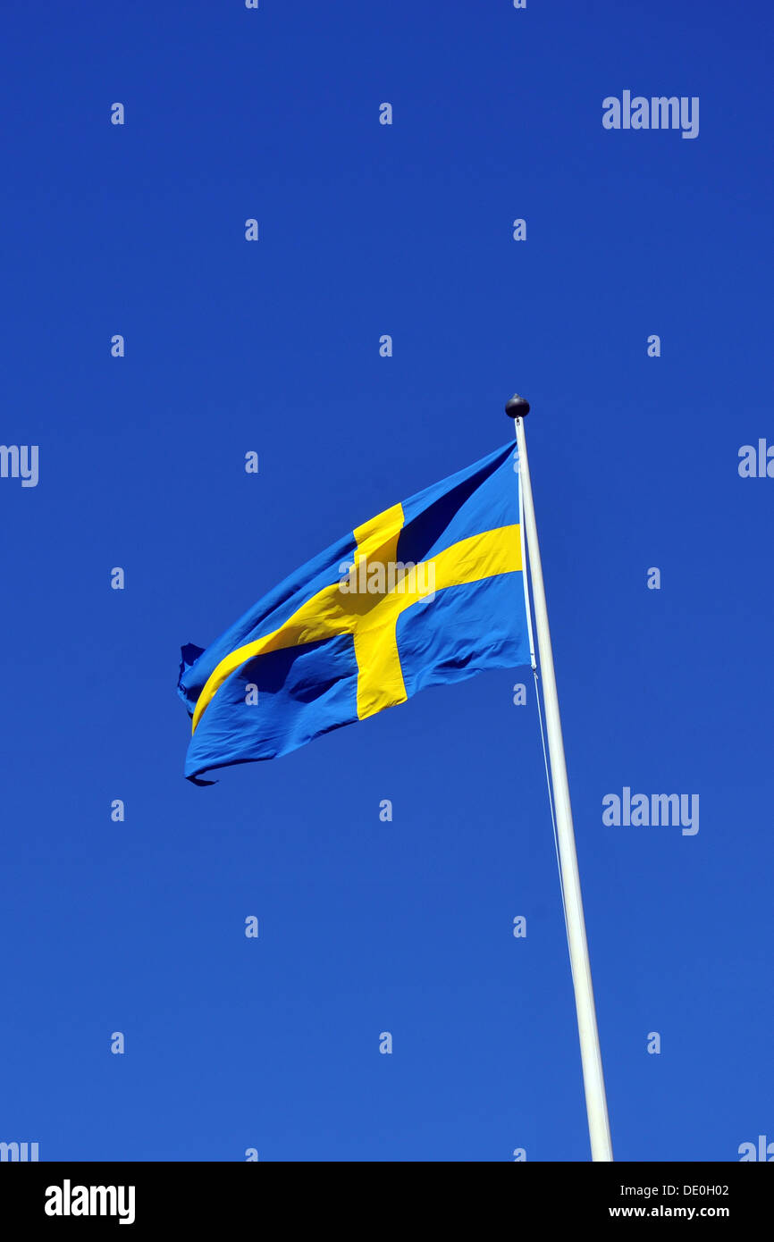The Swedish flag flying against a bright blue sky. Stock Photo