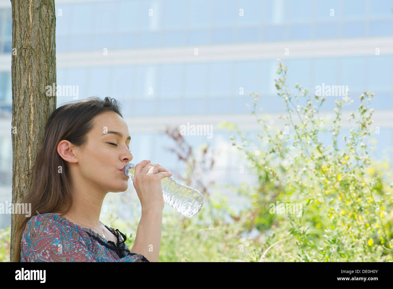 Woman drinking bottled water outdoors Stock Photo