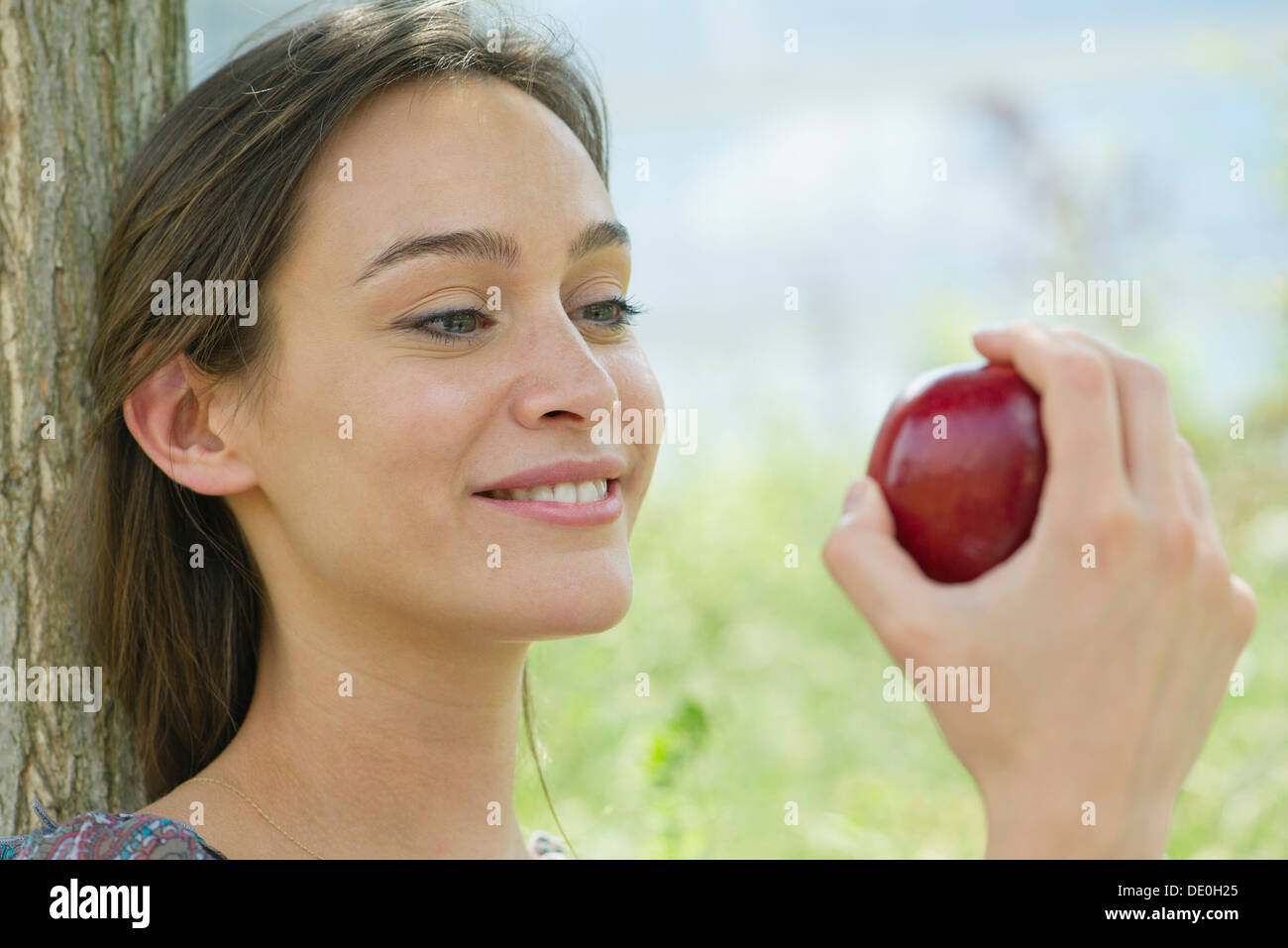 Woman sitting outdoors with apple Stock Photo