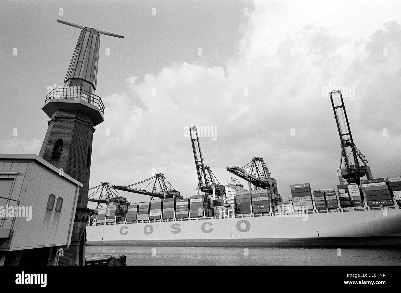 COSCO France at Tollerort Container Terminal (CTT) and Ellerholzhöft lighthouse in the German port of Hamburg. Stock Photo