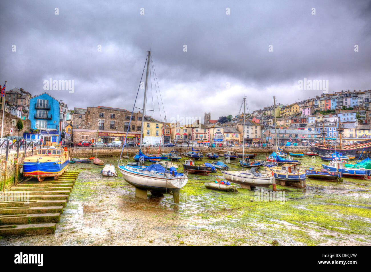 Devon harbour at low tide with no sea green seaweed and overcast sky at Brixham Devon England in HDR Stock Photo
