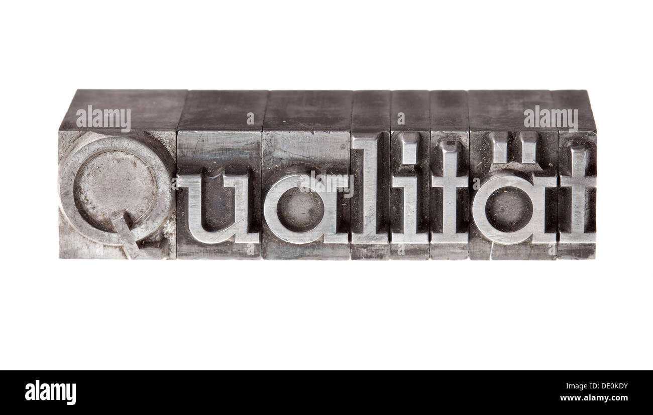 Old lead letters forming the word 'Qualitaet', German for quality Stock Photo
