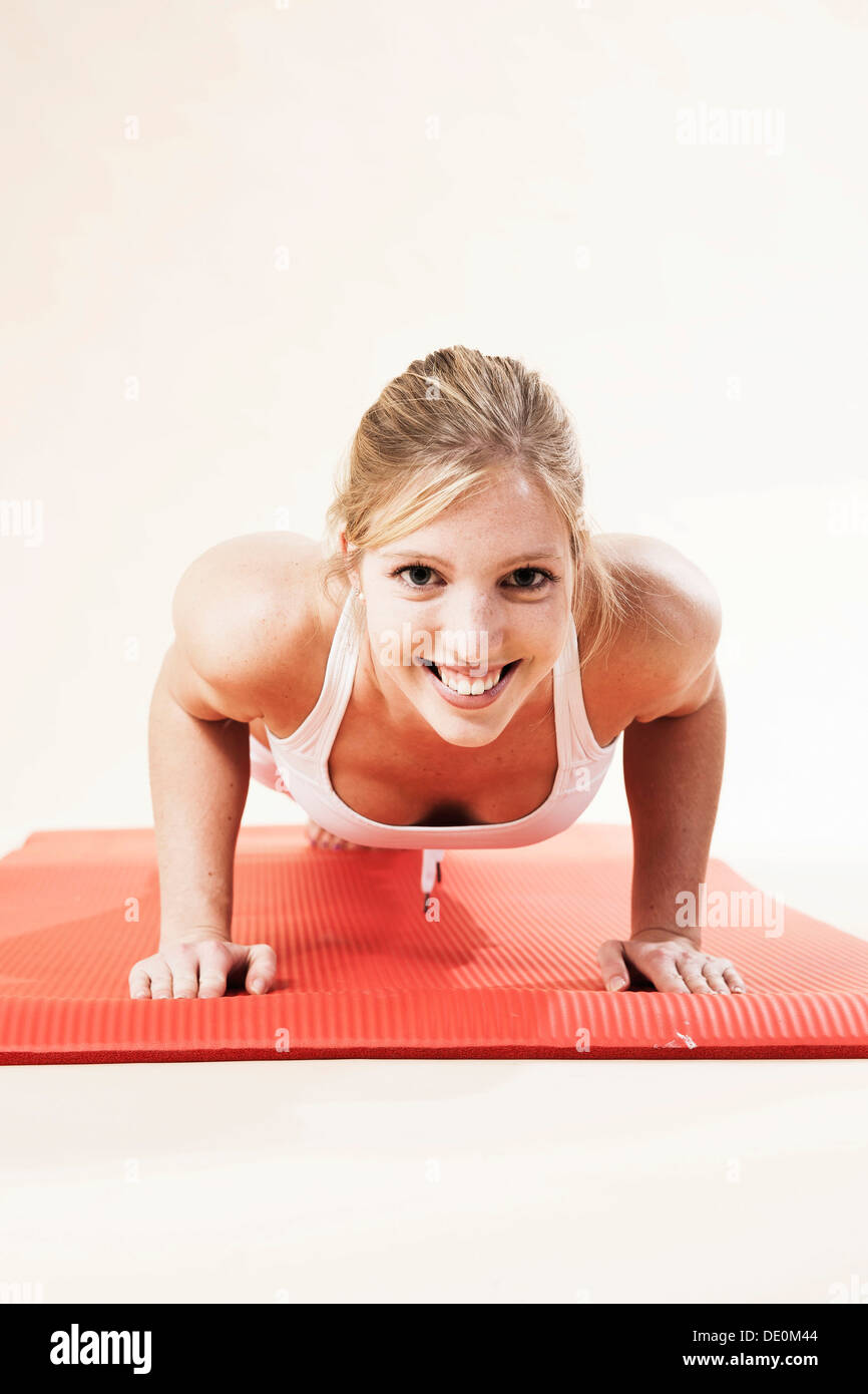 Young woman doing push-ups Stock Photo